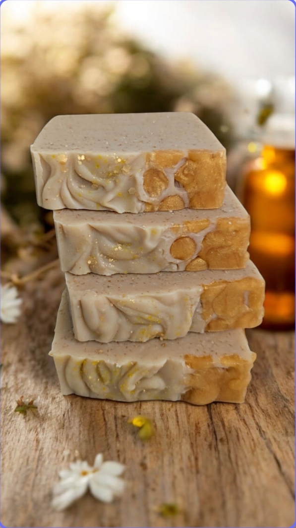 Oh eM Bee Soap Four stacked bars of handmade soap with a floral pattern, next to a bottle.